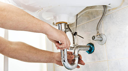Plumber using a wrench to tighten a siphon under a sink